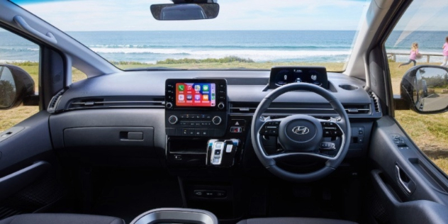 internal dash console of 2022 Hyundai Staria with view of grass and ocean through the windscreen